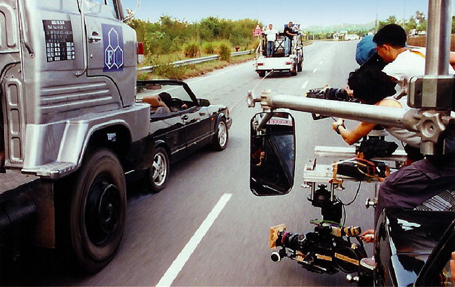  生 動 的 特 技 場 面 ， 由 裝 置 在 拖 車 上 的 攝 影 機 傳 神 捕 捉 。 （ 荷 蒙 猛 龍 特 技 羅 禮 賢 電 影 製 作 公 司 提 供 照 片 ， 謹 此 致 謝 。 ）</em>