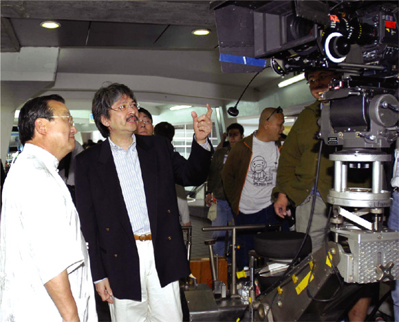 Secretary for Commerce, Industry and Technology, Mr John Tsang (right), admires the sophisticated equipment deployed in the shooting of Hollywood film 'Ultraviolet'.