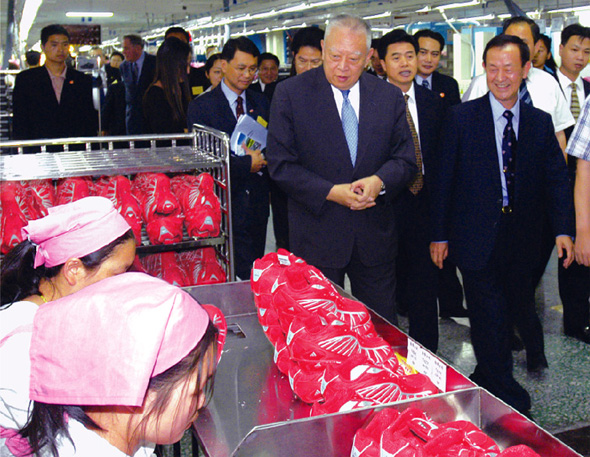  行 政 長 官 在 東 莞 參 觀 一 家 港 商 開 設 的 運 動 鞋 廠 。 