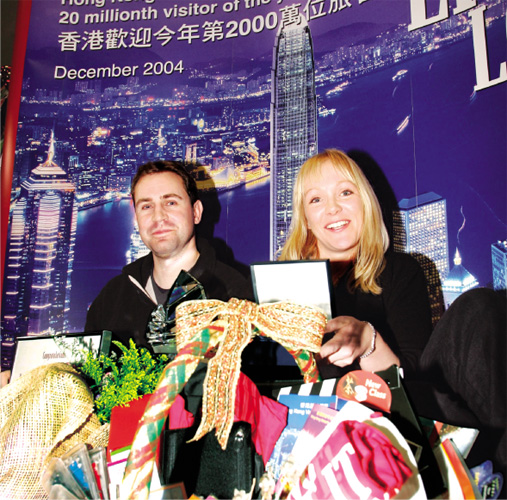 The 20-millionth visitor to Hong Kong during 2004, Ms Barbara Wallerbosch of the Netherlands, receives souvenirs and certificates on arrival.(Courtesy of Hong Kong Tourism Board)