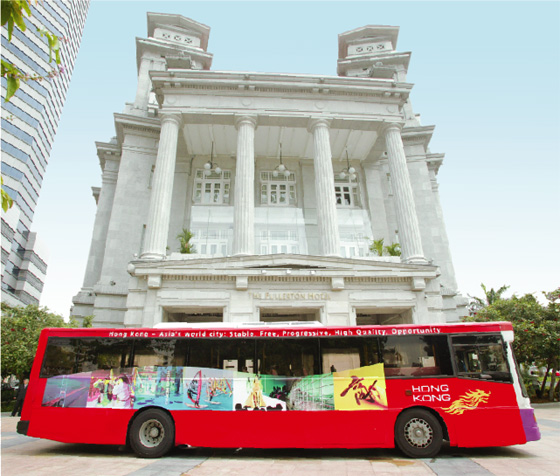  印 有 香 港 飛 龍 標 誌 的 巴 士 在 新 加 坡 街 頭 穿 梭 。 