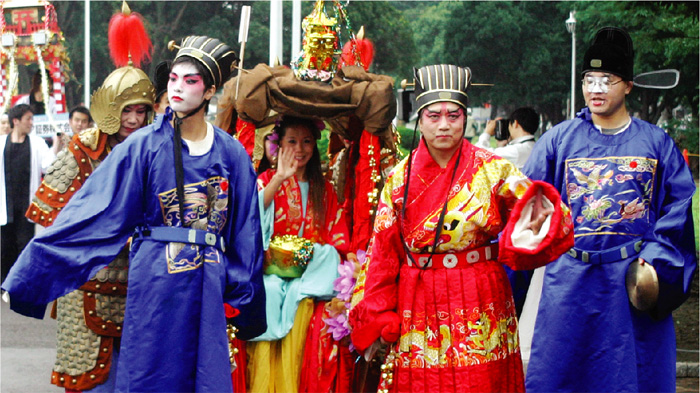  在 横 滨 举 行 的 香 港 抬 轿 比 赛 中 ， 五 彩 缤 纷 的 传 统 服 装 令 人 注 目 。 