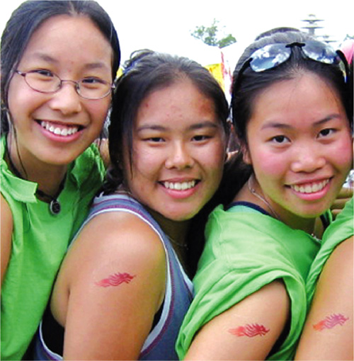  龙 舟 竞 渡 是 深 受 欢 迎 的 推 广 项 目 。 在 纽 约 举 行 的 赛 龙 舟 活 动 中 ， 几 位 少 女 展 示 臂 上 的 “ 飞 龙 ” 纹 身 。 